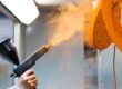orange powder coating of metal parts with spray gun