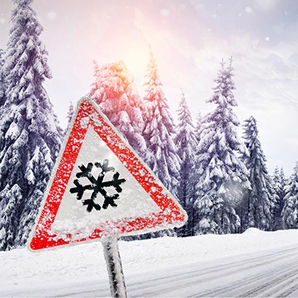 Winter – schneefall caution snow sign by snow covered road