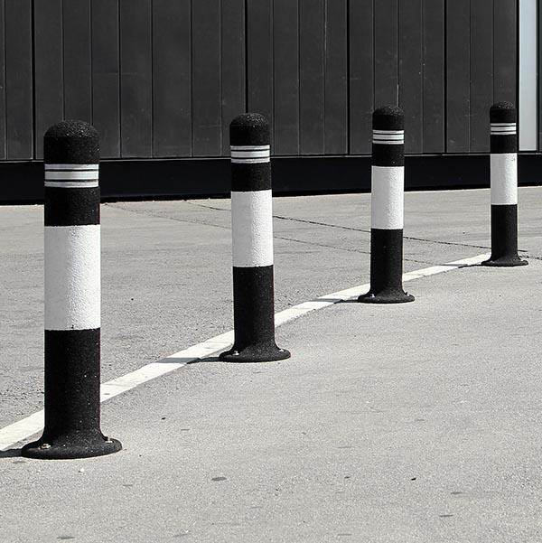 Parking columns on the parking lot black and white protective bollards