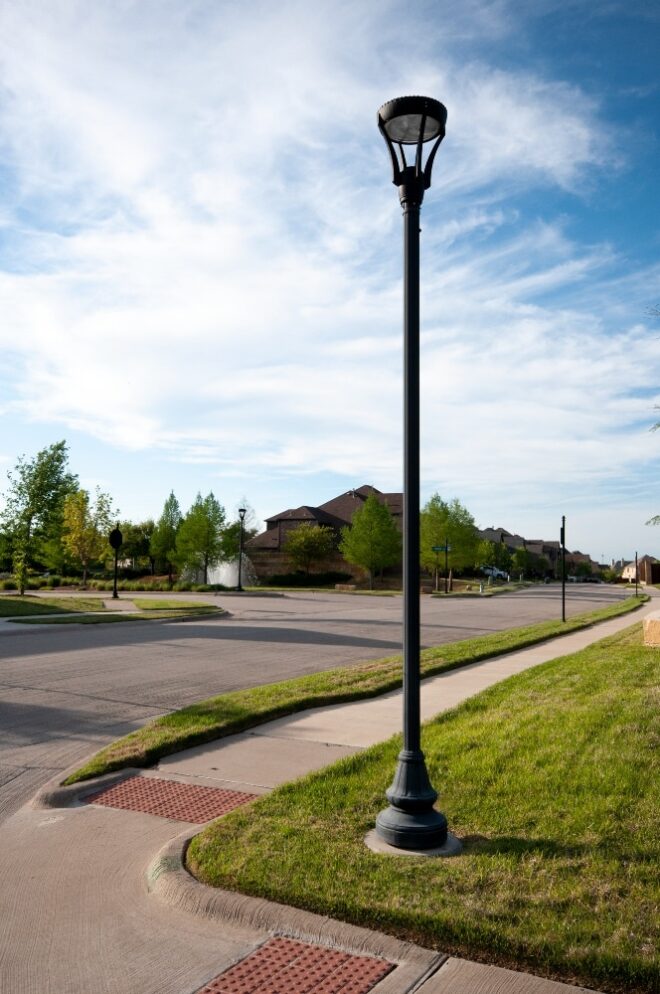 Modern lamp post on residential community road intersection.