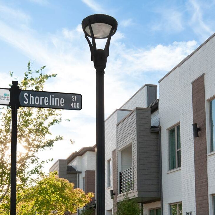Exterior Lighting for Multi-Tenant Communities A post top LED fixture and a street sign outside of a multifamily apartment complex.