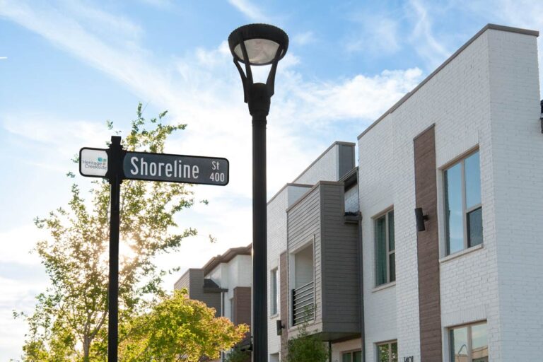Exterior Lighting for Multi-Tenant Communities A post top LED fixture and a street sign outside of a multifamily apartment complex.