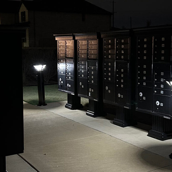 Solar Efficiency Two solar bollards illuminate a row of cluster mailbox units after dark.