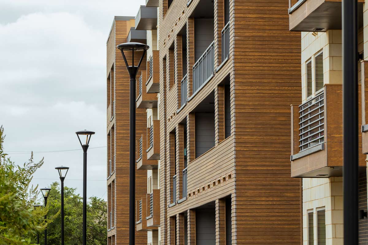 Lighting streets, parking, and pathways in multi-tenant locations A row of streetlamps outside of an apartment building