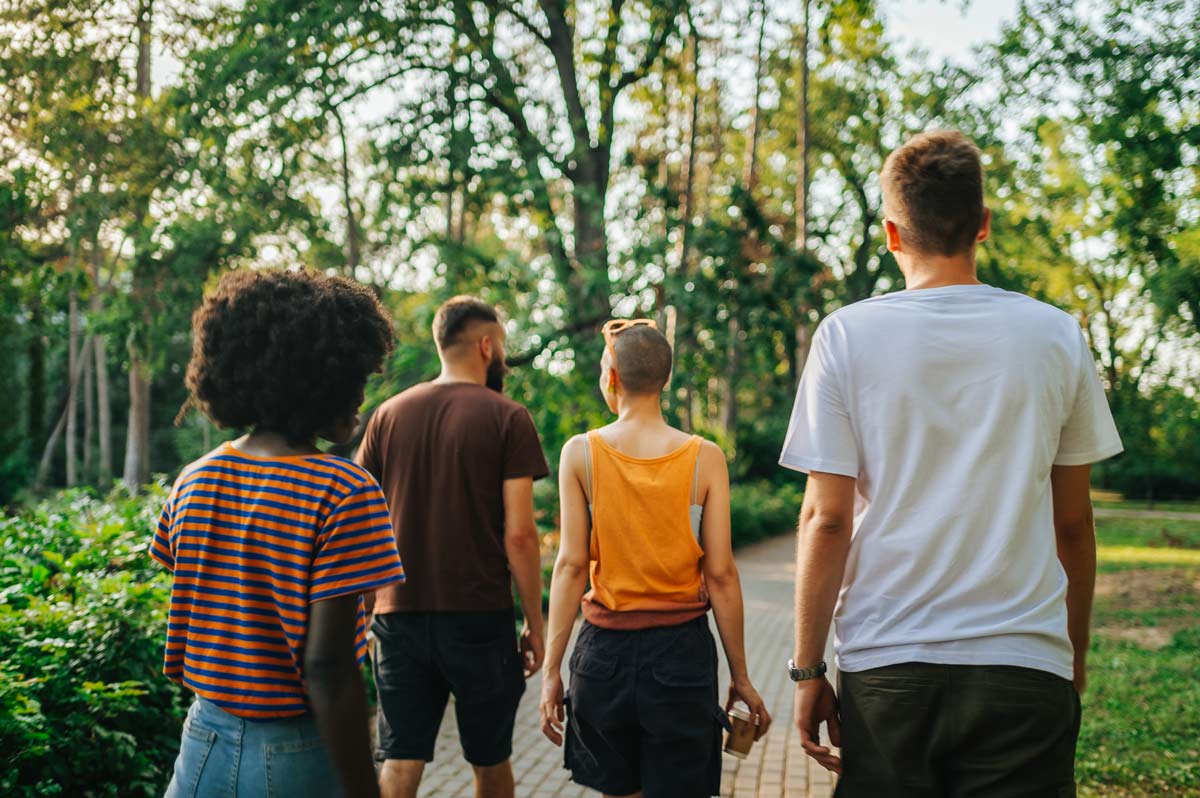 Streetscape investments boost community health and social benefits A group of four people walk down a path in a city park