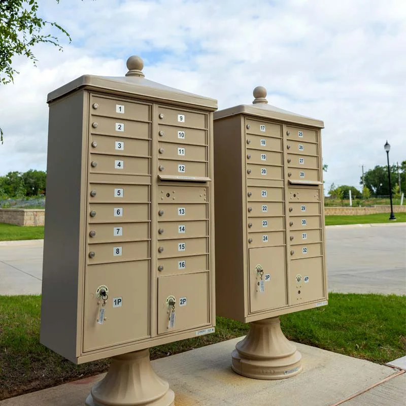 Two tan traditional cluster box units in a neighborhood